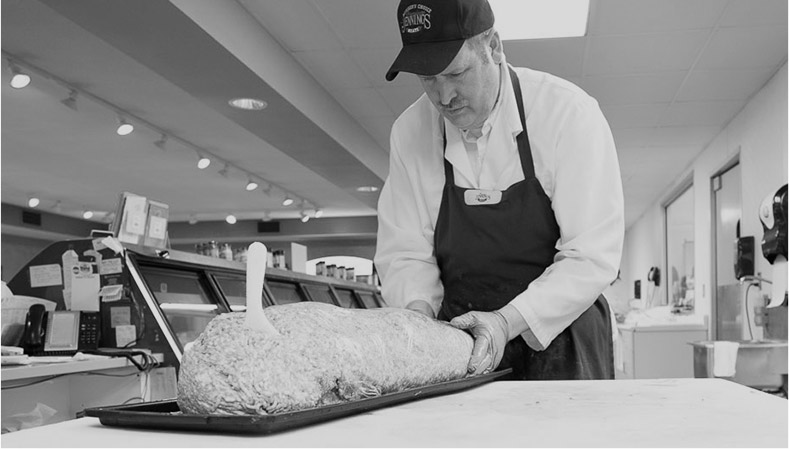 Jennings worker with meat display black and white